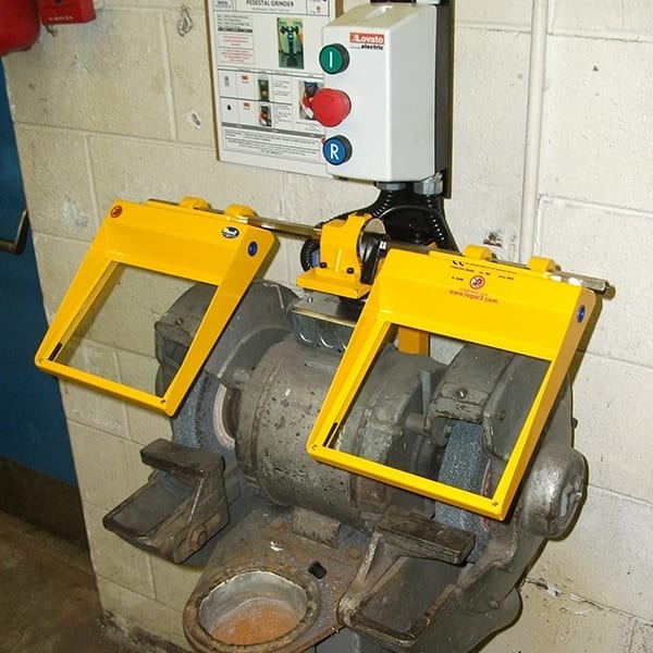 A big bench grinder with laminated glass safety shields.
