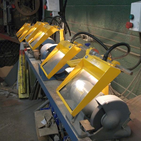 Bench grinders with work lights under the safety guards.