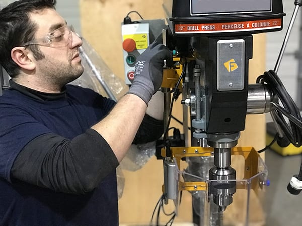 Technician installing drill press machine guarding in Ontario.