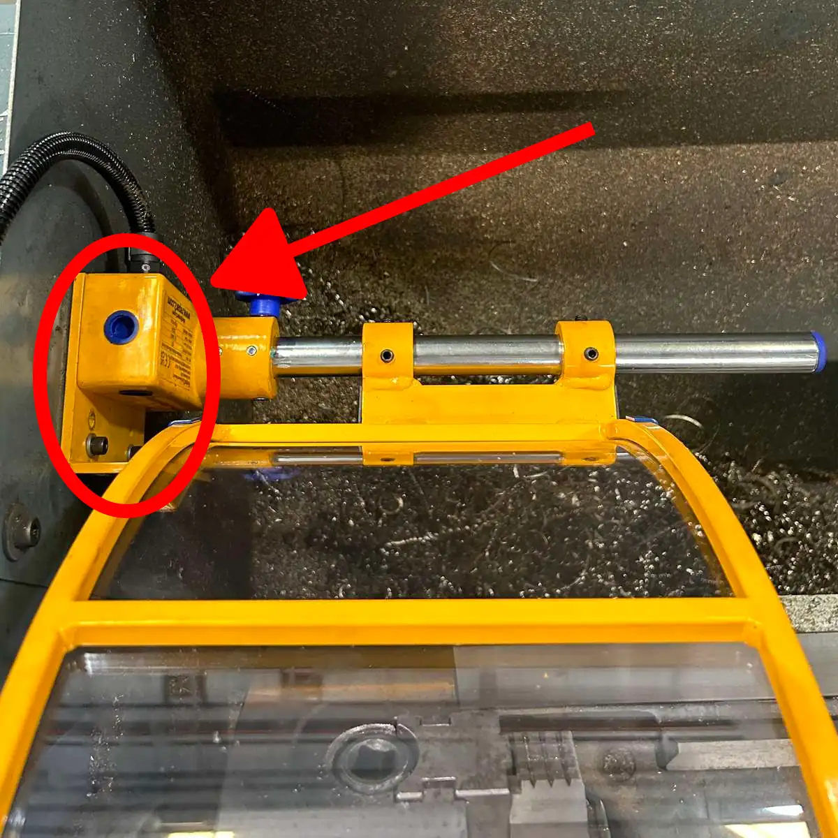An example of a flat installation point for a lathe chuck safety shield. An arrow points to the mounting bracket.