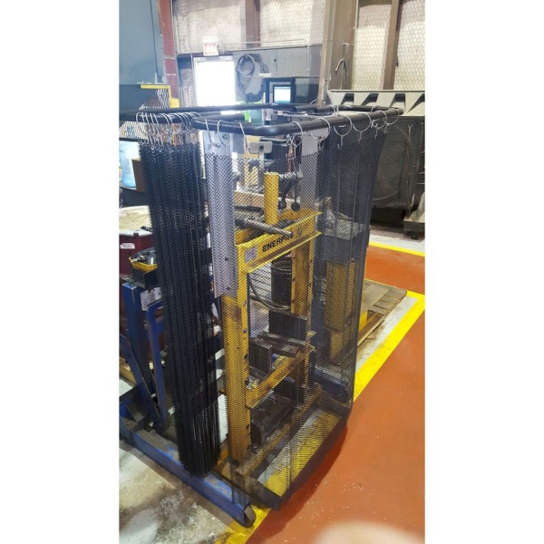 A hydraulic press with a steel mesh safety curtain installed for protection against ejections.