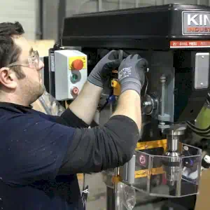 A Ferndale Safety machine safety field technician installing a safety shield on a drill press.