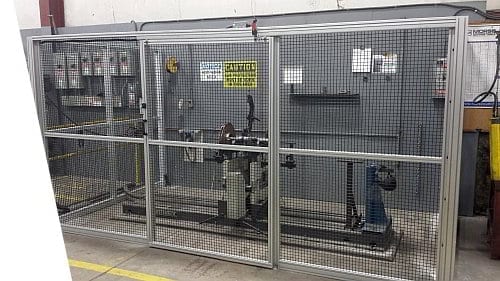 Custom PVC coated steel mesh perimeter guard around a balancing machine.  Includes an interlocked sliding door on the front.