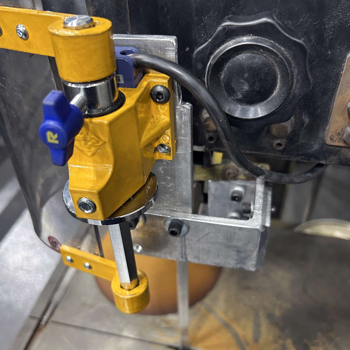 An example of a larger custom-fabricated mounting bracket used to mount a Ferndale Safety band saw safety guard.