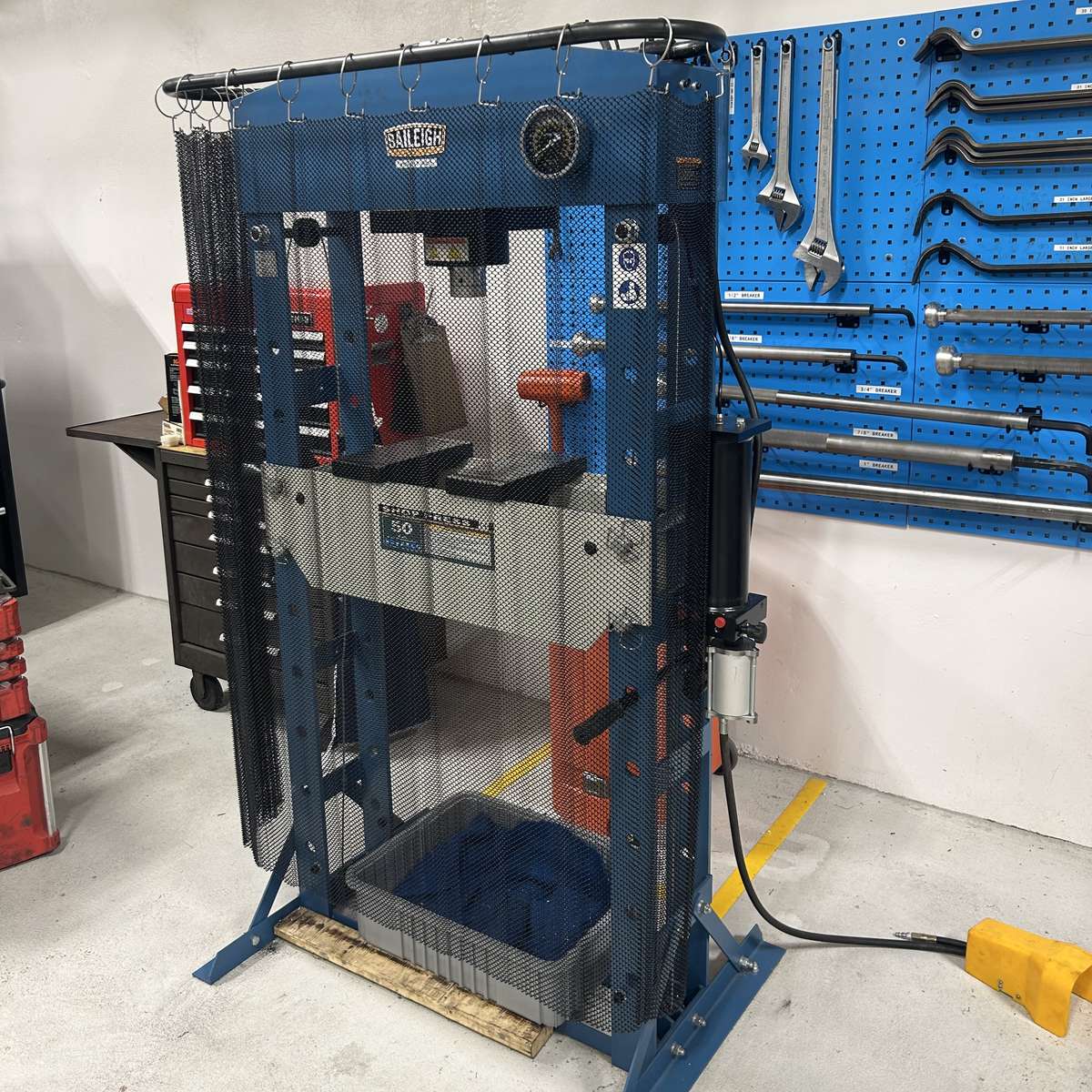 A hydraulic H-frame press with a steel mesh ejection curtain installed on it for protection by Ferndale Safety.