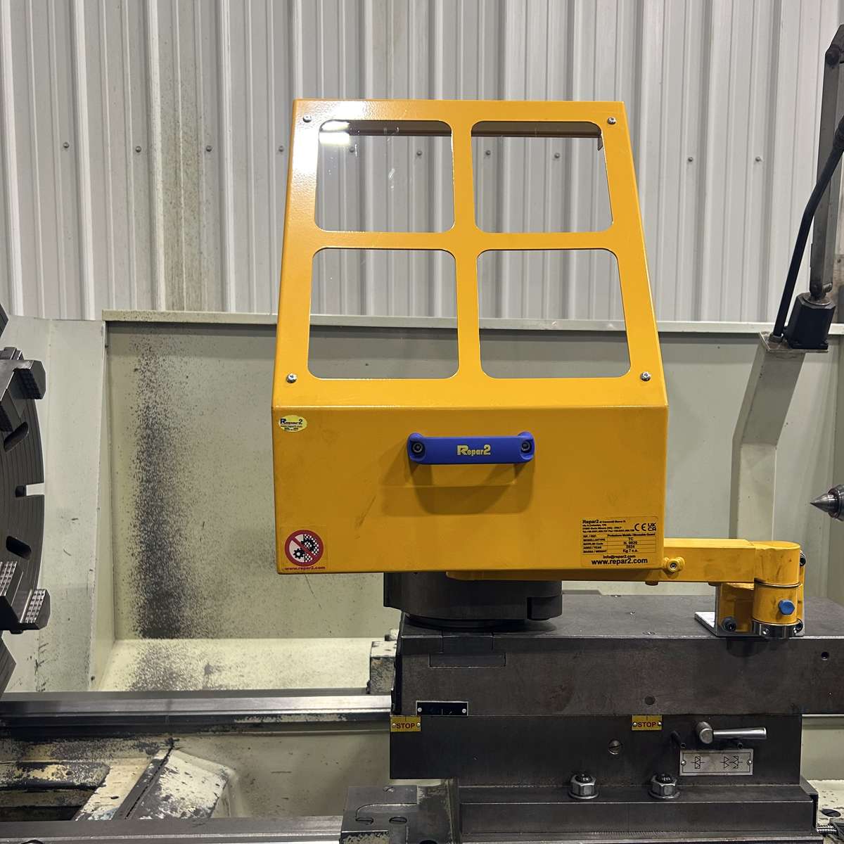 A safety chip shield shown mounted on the compound cross-slide of a large lathe.