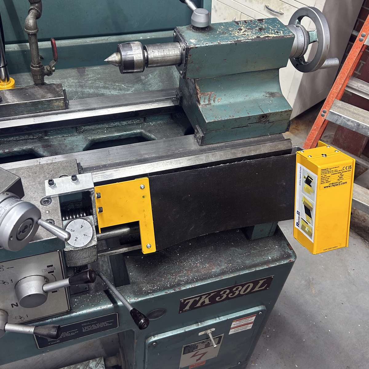 A lathe lead screw cover installed on the right side of a lathe carriage, towards the tailstock end of the machine.