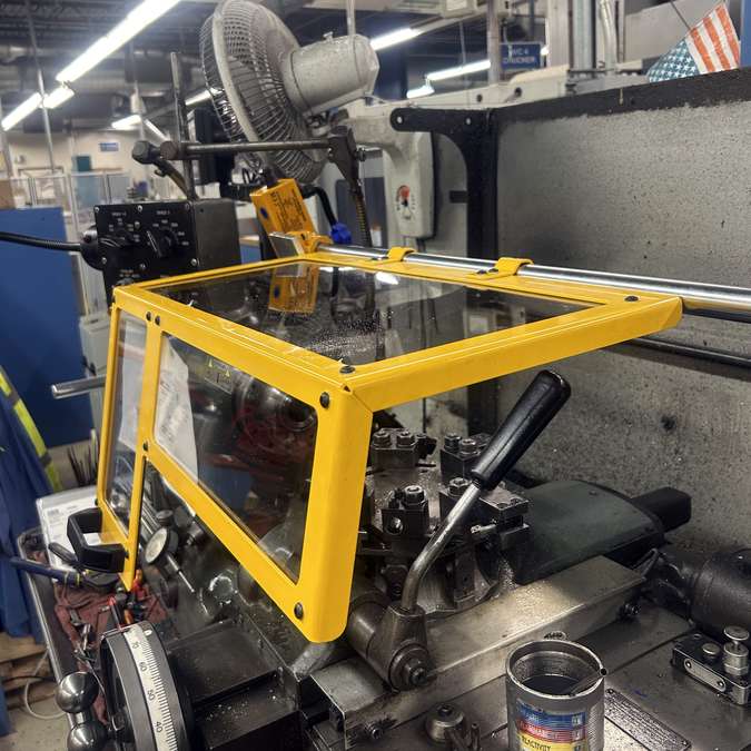 Side view of a Ferndale Safety small lathe chip guard shown installed on a lathe.