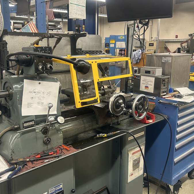 A wide-angle shot of a Ferndale Safety small lathe chip guard shown installed on a Hardinge toolroom lathe.