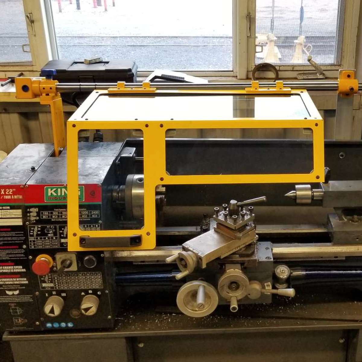Front view of a small toolroom lathe with a safety guard installed.