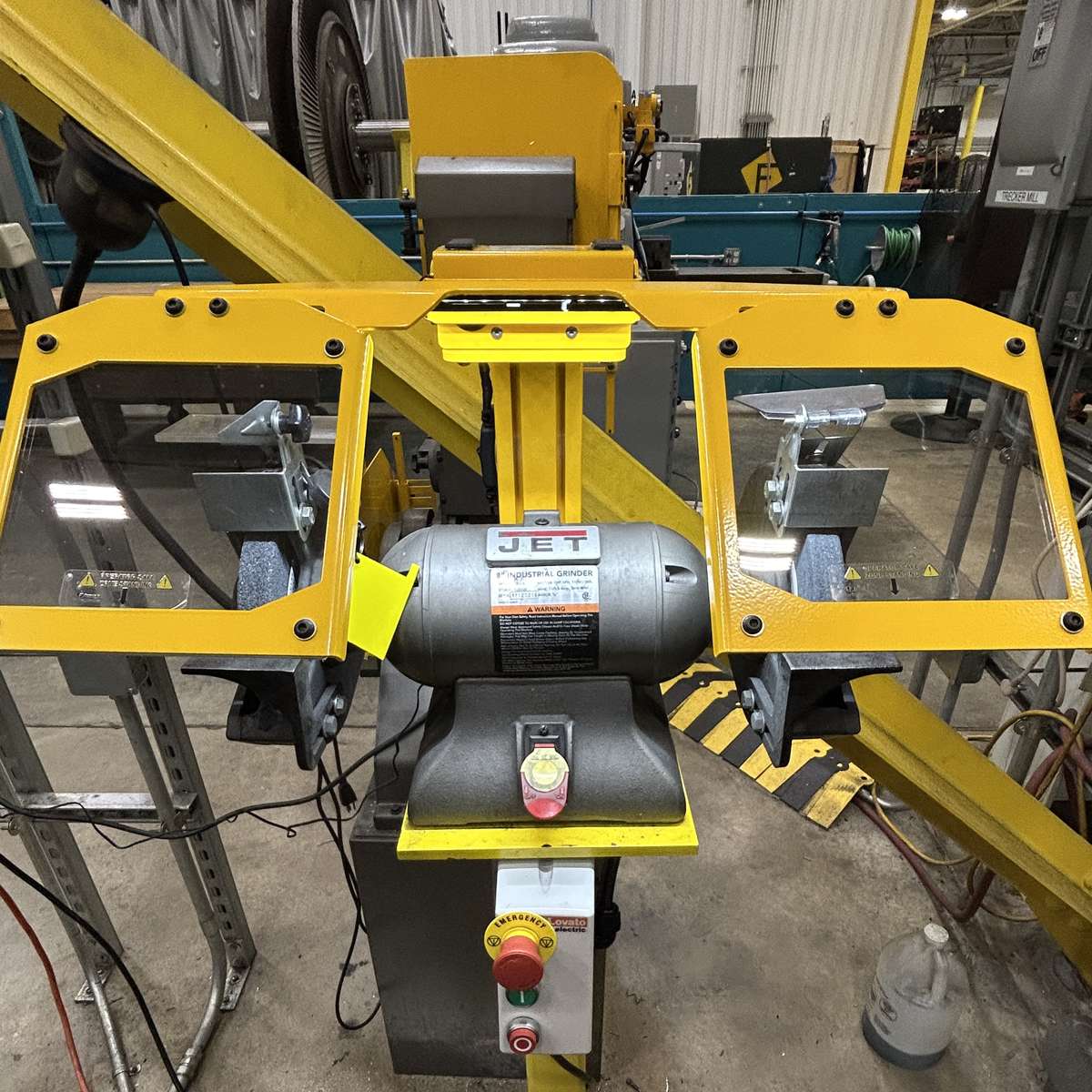 A Viziguard bench grinder shiels showing the built-in work light illuminating a bench grinder.